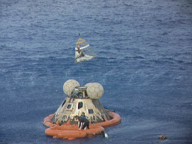 Astronaut John L. Swigert Jr., Apollo 13 command module pilot, is lifted aboard a helicopter in a 